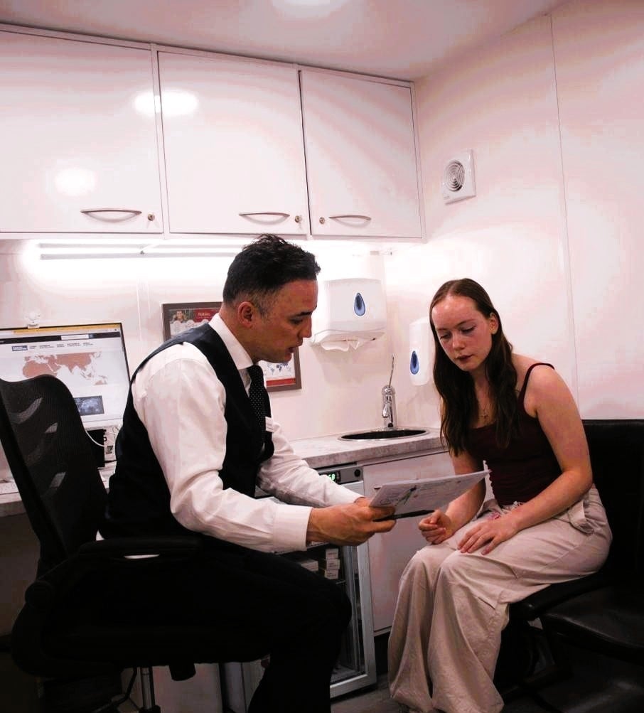 Mahyar Saremi reviewing travel health documentation with a patient during a consultation at Hampstead Heath Pharmacy in Hampstead, London NW3